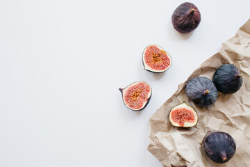 Fresh sliced and whole ripe figs on white background. Food photo background. Flat lay, Top view. Copy space.