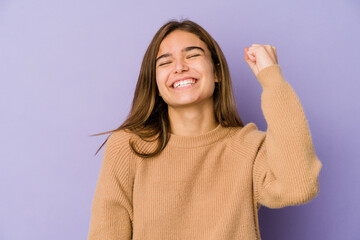 Young skinny caucasian girl teenager on purple background celebrating a victory, passion and...