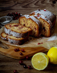 Traditional christmas cranberry lemon cake on a wooden table. Slices of homemade tasty cake with berries. Side view. Vertical orientation.