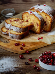Traditional christmas cranberry lemon cake on a wooden table. Slices of homemade tasty cake with berries. Side view. Vertical orientation.