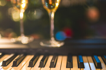 Piano keyboard and champagne glasses with soft blur bokeh background. Holidays concept, copy space © Hanna Tor