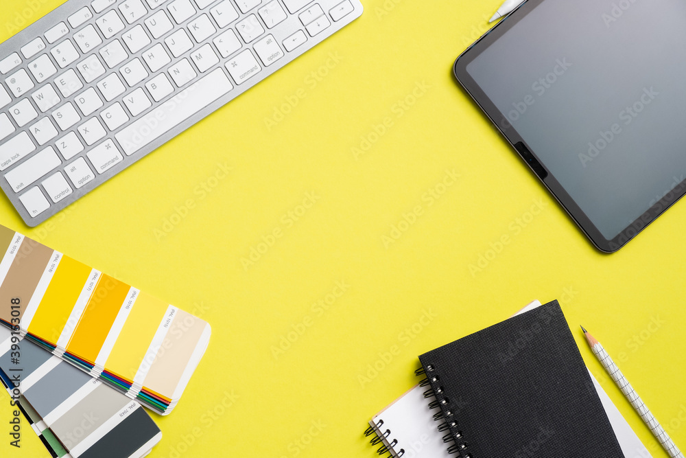 Poster graphic designer workspace top view with tablet, computer keyboard, ral color palette, notebook on y