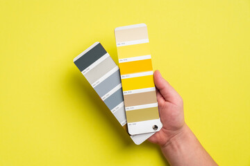 Palette with color of the year 2021 - Ultimate Gray and Illuminating yellow in man's hand. Trendy...