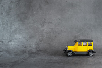 Obraz na płótnie Canvas Yellow toy retro car on gray background. Trendy colors 2021.