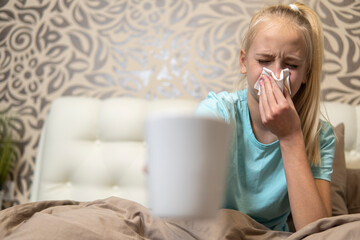 Teenage girl with blond hair sick in bed. close-up
