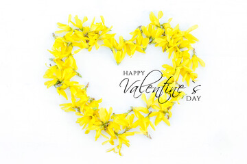 Heart symbol made of fresh yellow flowers on white background. Text Happy Valentine's Day in trend color 2021 Illuminating. background for discounts in store. Flat lay, top view.