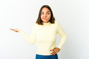 Young mixed race woman showing a copy space on a palm and holding another hand on waist.