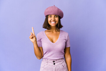 Young mixed race woman showing number one with finger.