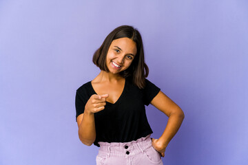 Young mixed race woman cheerful smiles pointing to front.