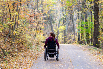 Women / Girl in Wheelchair on Path Rolling in the Fall /  Autumn