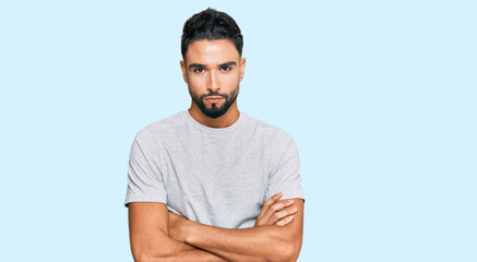 Young man with beard wearing casual grey tshirt skeptic and nervous, disapproving expression on...