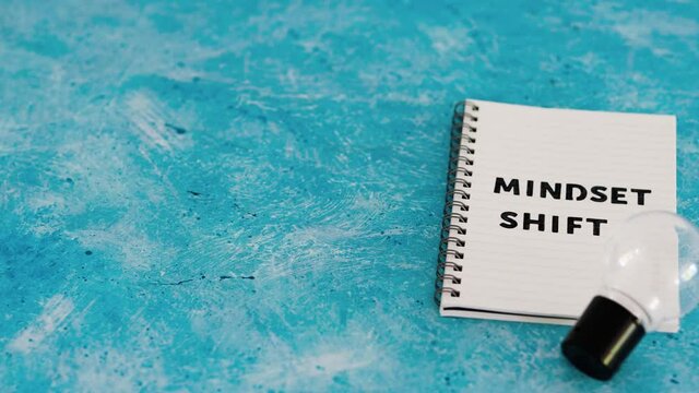 positivity and law of attraction, notepad with Mindset Shift text with light bulb next to it