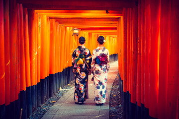 Women in traditional japanese kimonos walking at Fushimi Inari Shrine in Kyoto, Japan