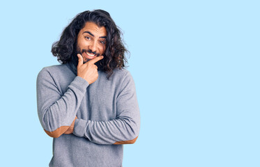 Young arab man wearing casual clothes looking confident at the camera smiling with crossed arms and hand raised on chin. thinking positive.