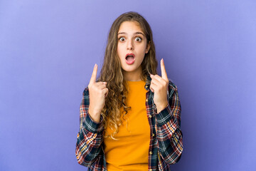 Young caucasian cute woman pointing upside with opened mouth.