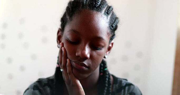 Pensive Black teen girl child thinking. Thoughtful sad depressed teenager adolescent girl