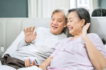 Old couple waving at grandchildren on a cellphone