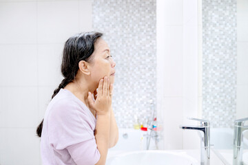 Senior woman doing treatment her face skin at home