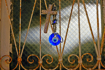 Orthodox cross and Turkish eye amulets on the door