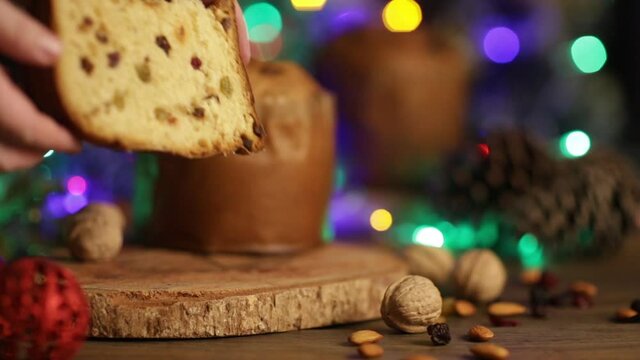 Delicious slice of Panettone with candied fruit on the table on a blurred background.