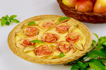 Tart with rose shape apple decorated and fresh apples.