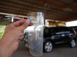 closeup of hand holding face shield for healthcare.