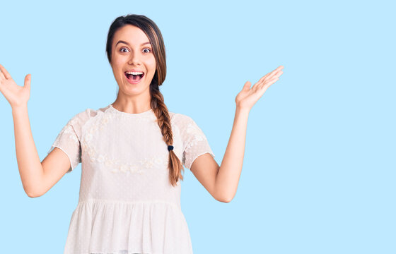 Young beautiful girl wearing casual t shirt celebrating victory with happy smile and winner expression with raised hands