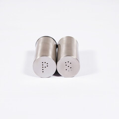 Steel pepper and salt shake on a white table.