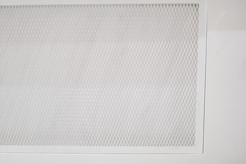 White cement walls and steel window on the side of the building. The window use steel grating as a componentor security and anti-theft.