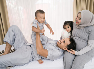 Obraz na płótnie Canvas Portrait of a happy family in piyama clothes. Family photo concept in bedroom