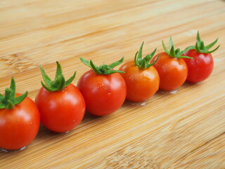 Ripe tomatoes on wooden board background, Fresh cherry tomatoes on wooden background, tomatoes on wooden background, Selective focus.