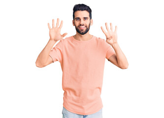 Fototapeta premium Young handsome man with beard wearing casual t-shirt showing and pointing up with fingers number nine while smiling confident and happy.