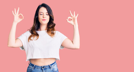 Beautiful young brunette woman wearing casual clothes relax and smiling with eyes closed doing meditation gesture with fingers. yoga concept.