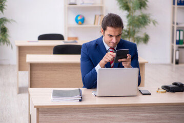 Young male employee sitting in the office