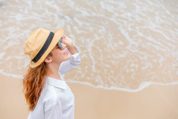 smiling young woman in sun hat and waring sun glasses on the  beach. summer, holidays, vacation, travel concept