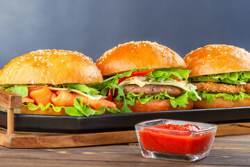 Set of various hamburgers on plate and sauce.