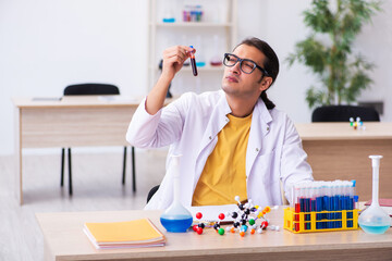 Young male chemist teacher in the classroom