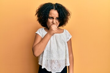 Young little girl with afro hair wearing casual clothes feeling unwell and coughing as symptom for...