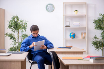 Young male teacher checking notes in the classroom