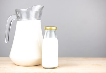 Bottles with fresh milk on a  wooden  table..Jug of fresh milk and glass on a  gray background, .Milk consumption nutritious, and healthy dairy products concept.