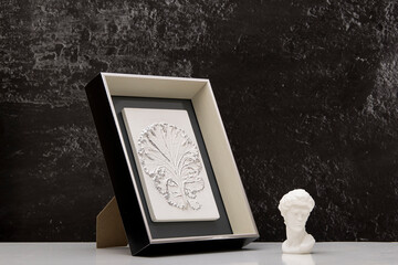 Stylish living room interior with botanical bas-relief cabbage leaf and statuette head of David for wall art. 3D plaster decor. Modern and luxury interior of room.