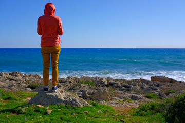 girl looks at the blue sea on a sunny day