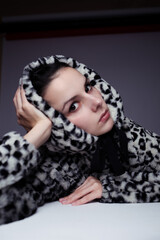 woman in hoodie, studio portrait on gray background