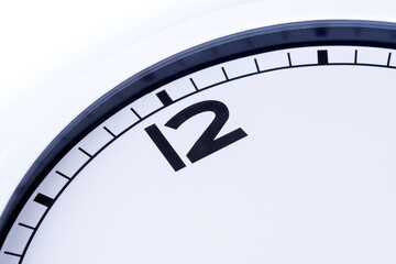 Close up quarter of an analog clock showing the hour of twelve