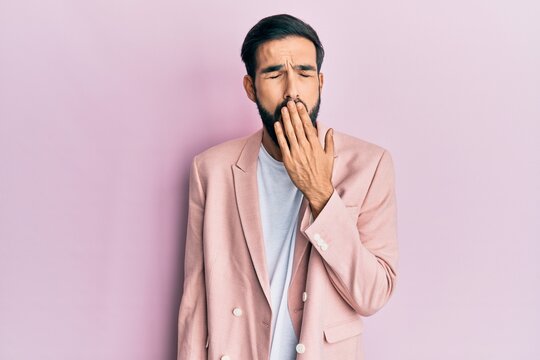 Young hispanic man wearing business jacket bored yawning tired covering mouth with hand. restless and sleepiness.