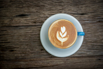 Cup of coffee with beautiful Latte art on wooden table