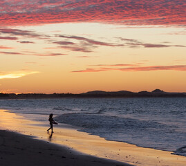 a girl bodyboarding at sunset