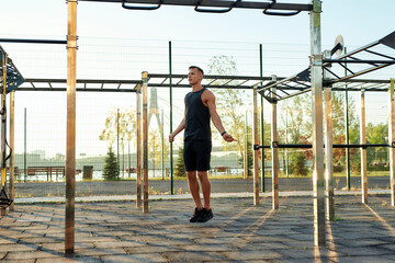 Sportive caucasian man exercising with skipping rope