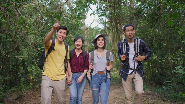 Group of multi ethnicity friend travel through a forest in the summer.