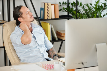 Tired graphic designer feels fatigue massaging tensed muscles of stiff neck trying to relieve pain...